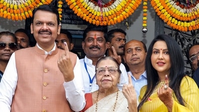 Devendra Fadnavis along with his mother Sarita Fadnavis and wife Amruta Fadnavis show their ink-marked fingers after casting their vote for the Maharashtra Assembly elections, in Nagpur. (Deepak Salvi / ANI)