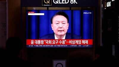 People watch a TV screen broadcasting a news report on South Korean President Yoon Suk Yeol's declaration of martial law. (REUTERS)