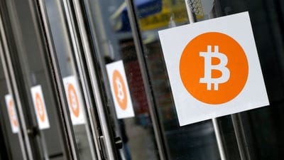 Bitcoin logos are displayed at the Inside Bitcoins conference and trade show on April 7, 2014, in New York. Bitcoin has topped the $100,000 mark (Mark Lennihan/AP)