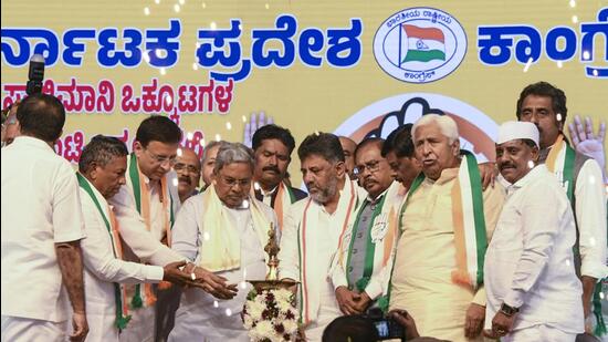 Karnataka Chief Minister Siddaramaiah with Deputy CM DK Shivakumar and Congress leader Randeep Singh Surjewala during the party's Jan Kalyan rally, in Hassan, on Thursday. (PTI)