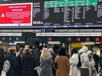 Travellers look at the information board at Victoria Station in London, Friday, Dec. 6, 2024 as rail travellers across Britain are facing disruption after a fault in a radio system used by drivers and signalers nationwide prompted cancellations across the network. 
