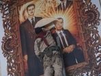 A Syrian opposition fighter tears up a painting depicting Syrian President Bashar Assad and his late father Hazef Assad at the Aleppo international airport in Aleppo, Syria.