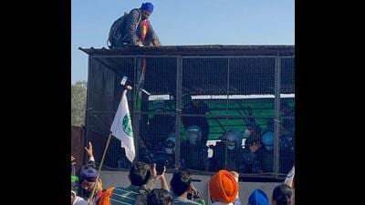 A protester manages to climb atop the shelter in which security forces have taken position on the Ghaggar bridge near Shambhu border on Friday. (HT Photo) A protester manages to climb atop the shelter in which security forces have taken position on the Ghaggar bridge near Shambhu border on Friday. (HT Photo)