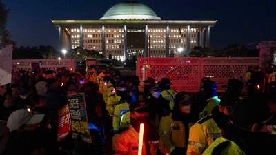 Police officers guard the National Assembly as protesters against South Korean President Yoon Suk Yeol gather outside to chant slogans in Seoul, South Korea on Friday. (AP) (AP) Police officers guard the National Assembly as protesters against South Korean President Yoon Suk Yeol gather outside to chant slogans in Seoul, South Korea on Friday. (AP) (AP)