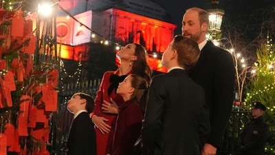 Britain's Prince William, right, Kate, Princess of Wales, Prince George, Princess Charlotte, center, and Prince Louis, left, look at messages on the Kindness Tree at the "Together At Christmas" carol service at Westminster Abbey in London, Britain, Friday, Dec. 6, 2024. (Jordan Pettitt/Pool photo via AP) (AP)