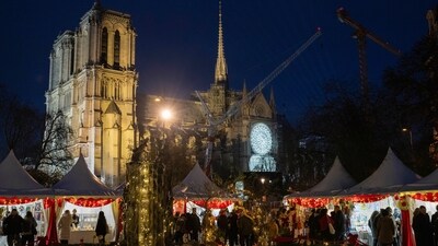 People stroll through a Christmas market next to Notre-Dame Cathedral in Paris on Friday ahead of the grand re-opening. (AP)