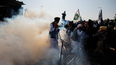 Farmers walk amidst tear gas as they gather on the day they march towards New Delhi to press for better crop prices promised to them in 2021 at the Shambhu barrier, a border crossing between Punjab and Haryana states on December 6. (REUTERS)