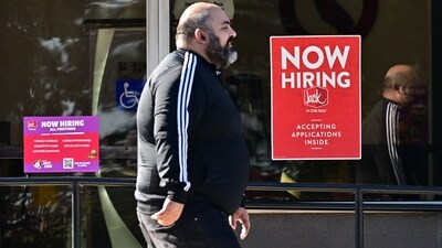 A pedestrian walks past a "Now Hiring" sign posted on a business storefront in San Gabriel, California (AFP) A pedestrian walks past a "Now Hiring" sign posted on a business storefront in San Gabriel, California (AFP)