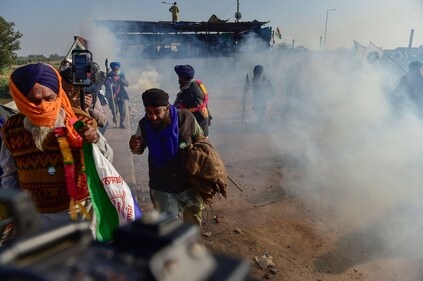 Farmers disperse after police fired tear gas to prevent them from marching towards Delhi. (AFP) Farmers disperse after police fired tear gas to prevent them from marching towards Delhi. (AFP)