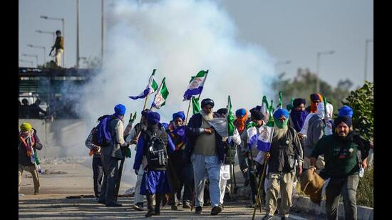 Farmers dispersing after police fired tear gas to prevent them from marching towards Delhi at Shambhu border in Punjab on Friday. (AFP Photo)