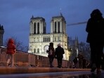 People walk past as France's iconic Notre Dame Cathedral is reflected in a puddle Saturday, Dec. 7, 2024 in Paris before the formal reopening for the first time since a devastating fire nearly destroyed the 861-year-old landmark in 2019. People walk past as France's iconic Notre Dame Cathedral is reflected in a puddle Saturday, Dec. 7, 2024 in Paris before the formal reopening for the first time since a devastating fire nearly destroyed the 861-year-old landmark in 2019.