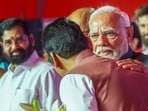 Prime Minister Narendra Modi with the newly sworn Maharashtra Chief Minister Devendra Fadnavis, left, and deputy chief minister Eknath Shinde (background left) during the swearing-in ceremony, in Mumbai, Thursday.