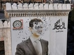 This aerial picture shows a bullet-riddled portrait of Syrian President Bashar al-Assad adorning Hama's municipality building after it was defaced following the capture of the city by anti government fighters on December 6. 