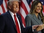 Donald Trump smiles accompanied by Melania Trump
