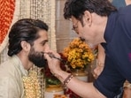 Venkatesh Daggubati puts kala tika on Naga Chaitanya's cheek.