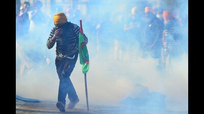 A farmer walks amid tear gas fired by police to prevent them from marching towards India's capital Delhi, at the Punjab-Haryana Shambhu Border in Punjab on Friday. (AFP) A farmer walks amid tear gas fired by police to prevent them from marching towards India's capital Delhi, at the Punjab-Haryana Shambhu Border in Punjab on Friday. (AFP)