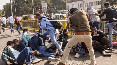 A police official lathicharges aspirants during their protest over normalization of the 70th Bihar Public Service Commission (BPSC) examination in Patna. (PTI) A police official lathicharges aspirants during their protest over normalization of the 70th Bihar Public Service Commission (BPSC) examination in Patna. (PTI)