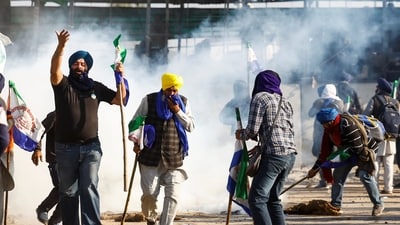 Farmers react as they try to get cover from tear gas, while they march towards New Delhi to press for better crop prices promised to them in 2021 at the Shambhu barrier, a border crossing between Punjab and Haryana. REUTERS (REUTERS)