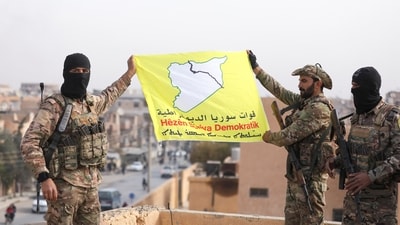 Members of the Kurdish-led Syrian Democratic Forces (SDF) a flag in Deir al-Zor, after U.S.-backed alliance led by Syrian Kurdish fighters captured Deir el-Zor, the government's main foothold in the vast desert, according to Syrian sources, in Syria December 7, 2024. (REUTERS)