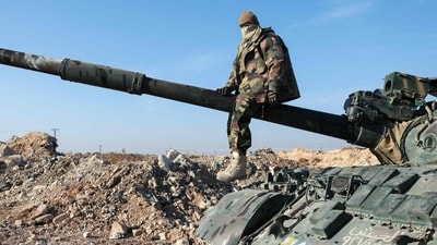 A militant poses for a picture after anti-government fighters seized Syrian army military equipment and vehicles that were abandoned on the highway to Damascus, as they reach the town of Suran north of Syria's Hama city (AFP)