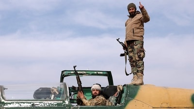 &nbsp;Anti government fighters gesture as they check a Syrian army jet after they took over a military airbase near the central city of Hama,&nbsp; (AFP)