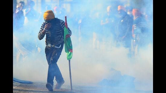 A farmer walks amid tear gas fired by police to prevent them from marching towards India's capital Delhi, at the Punjab-Haryana Shambhu Border in Punjab on Friday. (AFP)