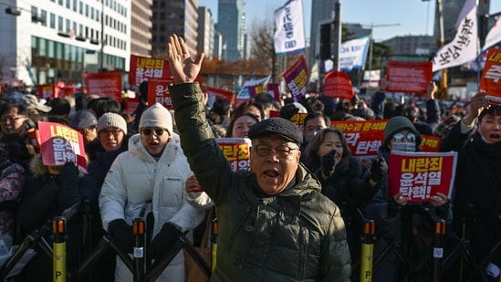 Shin Jae-hyung (C), a 66-year-old protester who participated in South Korea's pro-democracy mass protests in the 1970s and the 80s, takes part in a protest calling for the ouster of South Korea President Yoon Suk Yeol. (AFP)