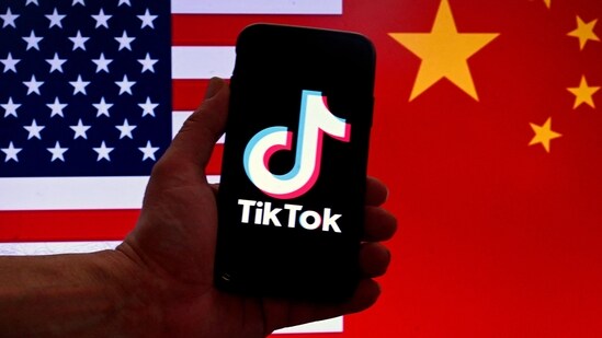 TikTok logo is displayed on the screen of an iPhone in front of a US flag and Chinese flag background in Washington, DC. (AFP)