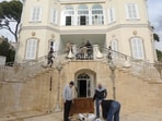 People remove the Syrian flag from the entrance of ousted president Bashar al-Assad's Al-Muhajirin residence in Damascus on Sunday. 