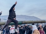 This screen grab taken from AFPTV shows people sitting on a tank as they gather at Umayyad Square in Damascus on December 8, 2024.