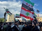 People hold Syrian opposition and Lebanese flags as they celebrate, after Syrian rebels announced that they have ousted President Bashar al-Assad, in Tripoli.