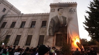 Residents in Hama set ablaze a large banner bearing a picture of Syria's President Bashar al-Assad hanging on the facade of a municipal building. (AFP) Residents in Hama set ablaze a large banner bearing a picture of Syria's President Bashar al-Assad hanging on the facade of a municipal building. (AFP)