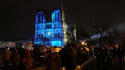 Crowds stand outside Notre-Dame Cathedral as it is illuminated during a ceremony to mark the re-opening of the landmark Cathedral. (AFP) Crowds stand outside Notre-Dame Cathedral as it is illuminated during a ceremony to mark the re-opening of the landmark Cathedral. (AFP)