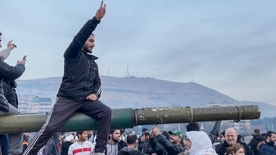 This screen grab taken from AFPTV shows people sitting on a tank as they gather at Umayyad Square in Damascus on December 8, 2024. (AFP) This screen grab taken from AFPTV shows people sitting on a tank as they gather at Umayyad Square in Damascus on December 8, 2024. (AFP)