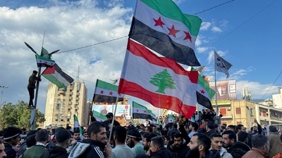 People hold Syrian opposition and Lebanese flags as they celebrate, after Syrian rebels announced that they have ousted President Bashar al-Assad, in Tripoli. (Reuters)