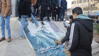 People kick a poster depicting Syrian President Bashar al Assad after Syria's army command notified officers on Sunday that President Bashar al-Assad's 24-year authoritarian rule has ended (REUTERS)