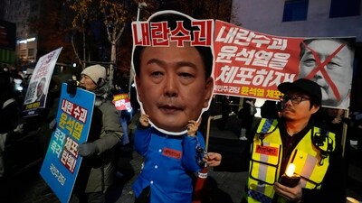 A participant wearing a mask of South Korean President Yoon Suk Yeol attends a rally demanding his impeachment outside the National Assembly in Seoul, South Korea,.The signs read "Arrest Yoon Suk Yeol." (AP)