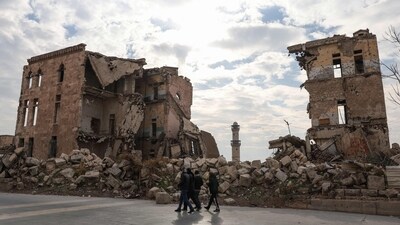 Syrians walk past one of Aleppo's destroyed structures near the northern city's historic citadel. (AFP) Syrians walk past one of Aleppo's destroyed structures near the northern city's historic citadel. (AFP)