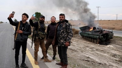 Armed men pose for pictures near a military vehicle belonging to the Syrian regime forces and seized by anti government forces. (AFP) Armed men pose for pictures near a military vehicle belonging to the Syrian regime forces and seized by anti government forces. (AFP)