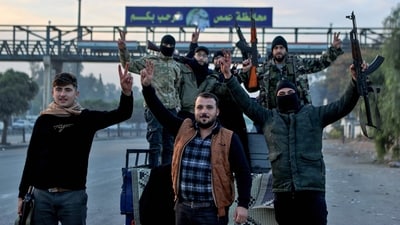 Syrian rebel fighters celebrate at the entrance of Homs province early on December 8, 2024, after rebel forces entered Syria's third city overnight. Hayat Tahrir al-Sham (HTS) and allied anti-government factions have pressed a lightning offensive since November 27, sweeping swathes of the country from government control, including major cities Aleppo, Hama and Homs. (AFP) Syrian rebel fighters celebrate at the entrance of Homs province early on December 8, 2024, after rebel forces entered Syria's third city overnight. Hayat Tahrir al-Sham (HTS) and allied anti-government factions have pressed a lightning offensive since November 27, sweeping swathes of the country from government control, including major cities Aleppo, Hama and Homs. (AFP)
