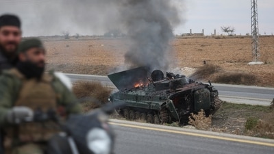 Syrian opposition fighters drive past a burning government armoured vehicle south of Hama, Syria, on Dec. 7, 2024. (AP) Syrian opposition fighters drive past a burning government armoured vehicle south of Hama, Syria, on Dec. 7, 2024. (AP)