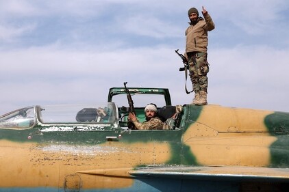 Anti government fighters gesture as they check a Syrian army jet after they took over a military airbase near the central city of Hama. (AFP) Anti government fighters gesture as they check a Syrian army jet after they took over a military airbase near the central city of Hama. (AFP)