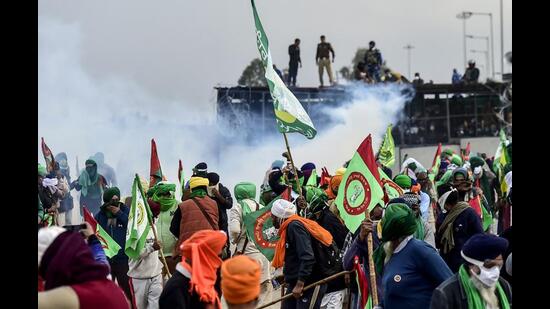 Farmers cover their faces with cloth as security personnel fire tear gas during a protest at the Punjab-Haryana state Shambhu border in Punjab On Sunday. (AFP)