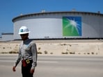 An Aramco employee walks near an oil tank at Saudi Aramco's Ras Tanura oil refinery and oil terminal in Saudi Arabia.
