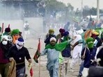 Farmers cover their faces with cloth as police fire tear gas during a protest at the Punjab-Haryana state Shambhu border in Punjab on Sunday. Farmers cover their faces with cloth as police fire tear gas during a protest at the Punjab-Haryana state Shambhu border in Punjab on Sunday.