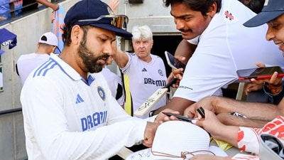 India's captain Rohit Sharma (C) signs autographs to the fans on the third day of the second cricket Test match between Australia and India at the Adelaide Oval in Adelaide on December 8 (AFP)