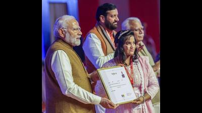 PM Modi presents an appointment certificate to a prospective Bima Sakhi in Panipat on Monday. (ANI) PM Modi presents an appointment certificate to a prospective Bima Sakhi in Panipat on Monday. (ANI)