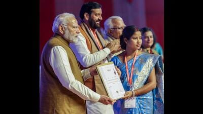 Prime Minister Narendra Modi presents an appointment certificate to a prospective Bima Sakhi at the launch of LIC Bima Sakhi Yojana, in Panipat on Monday. Haryana CM Nayab Singh Saini also present. (DPR PMO) Prime Minister Narendra Modi presents an appointment certificate to a prospective Bima Sakhi at the launch of LIC Bima Sakhi Yojana, in Panipat on Monday. Haryana CM Nayab Singh Saini also present. (DPR PMO)