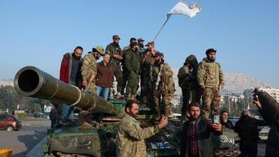 Rebel fighters stand on a tank, after rebels seized the capital and ousted President Bashar al-Assad, in Damascus, Syria, on December 9 (REUTERS) Rebel fighters stand on a tank, after rebels seized the capital and ousted President Bashar al-Assad, in Damascus, Syria, on December 9 (REUTERS)