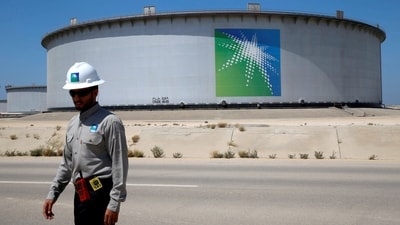 An Aramco employee walks near an oil tank at Saudi Aramco's Ras Tanura oil refinery and oil terminal in Saudi Arabia. (Reuters)